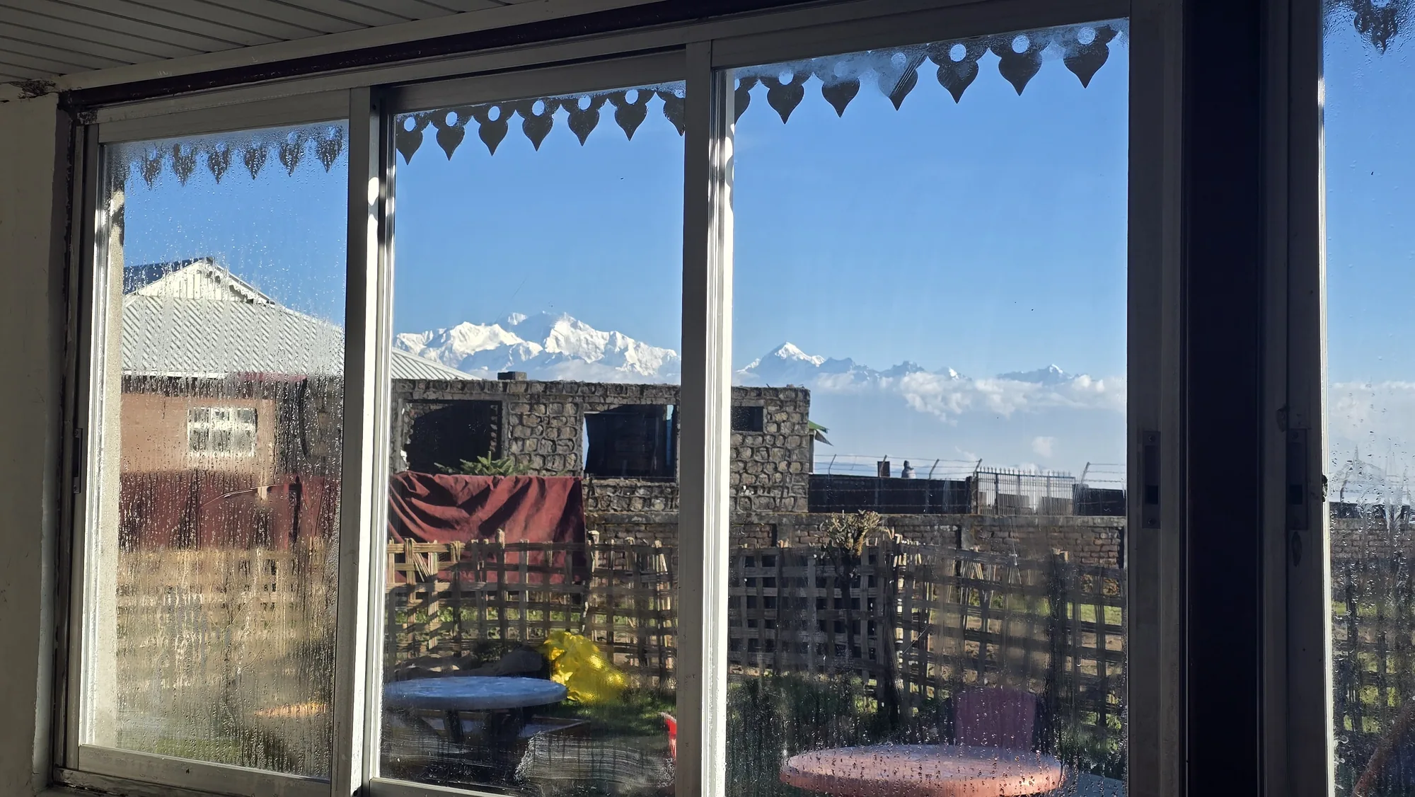 Dining room window framing a Himalayan view